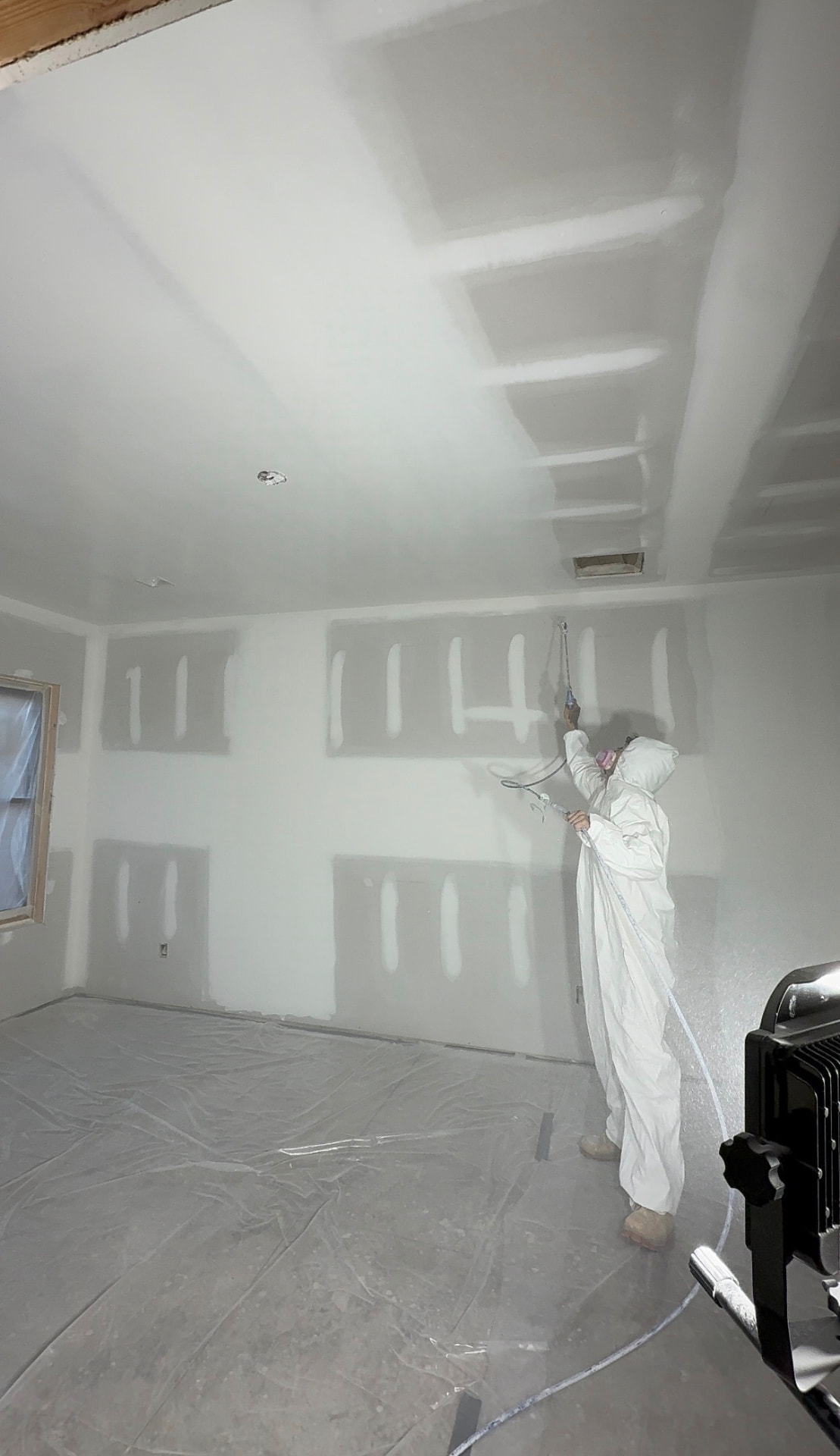 Spraying a finished drywall ceiling on a new build