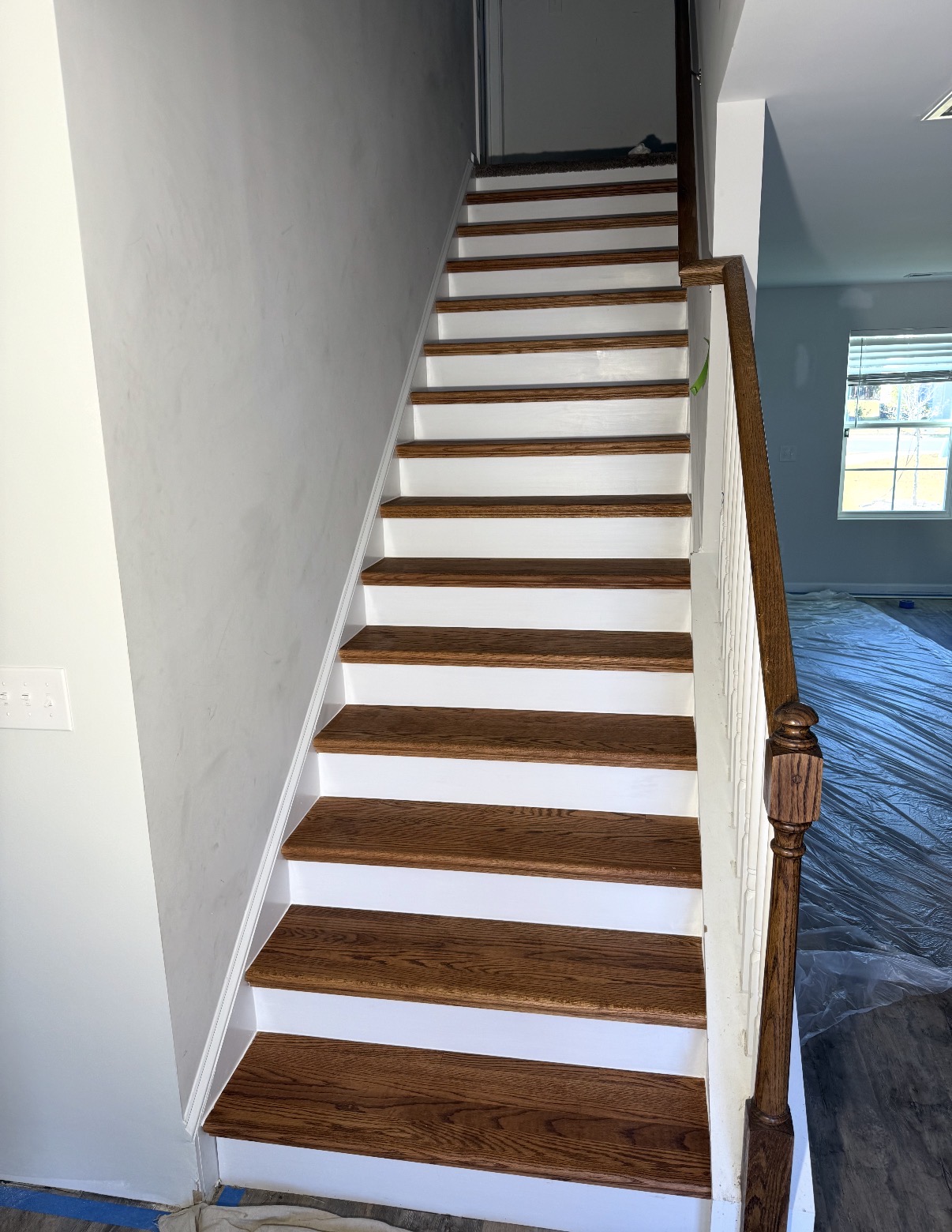Refinished wooden stair treads paired with freshly painted white risers — Luxury Vinyl Plank Flooring Install in Chapin, SC