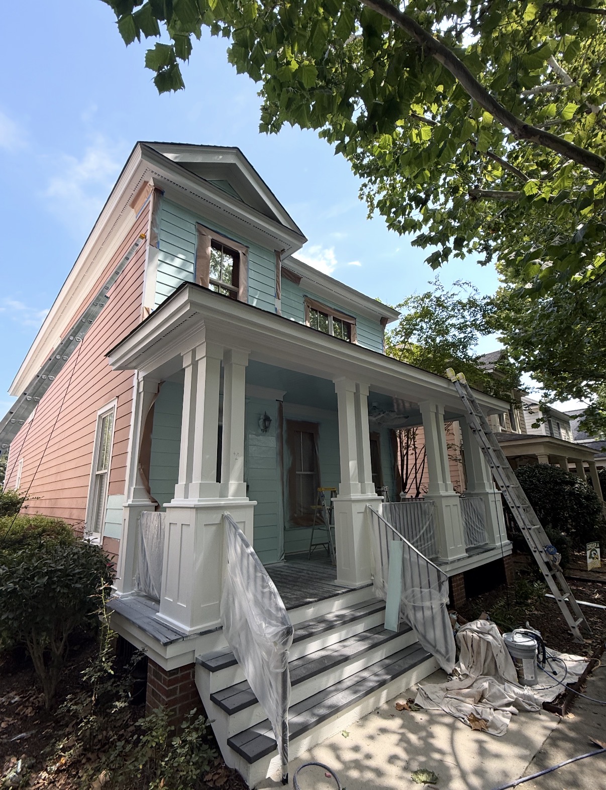 Before: Two-story historic home on scaffolding being repainted from salmon pink to a lighter color — Historic Porch and Siding Repaint, Exterior Painting by CJC Remodeling